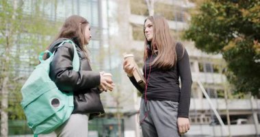 Kahve İçtikten sonra Sohbet Eden İki Genç Kız: Bir Şehir Merkezinde Samimi Bir Arkadaşlık ve Bağlantı Anı