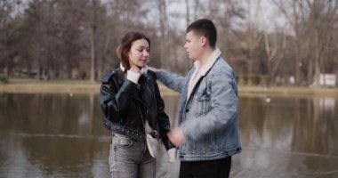 Genç bir çift parktaki bir göletin yanından geçiyor. Adam kolunu kadına doladı. El ele tutuşup birbirlerine gülümserler..