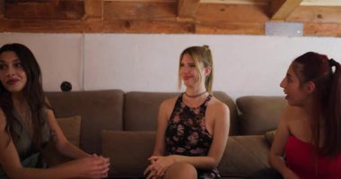 Dört arkadaş kanepede kız kıza gülüp sohbet ediyorlar. Sıcak tavan arasında içki ve atıştırmalıkların tadını çıkarıyorlar..