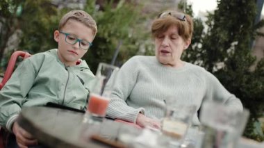 Büyükannem ve torunum dışarıda bir kafede birlikte vakit geçirip içki içip sohbet ediyorlar..