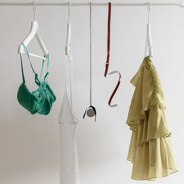 Vêtements femme suspendus au-dessus du mur blanc — Photo