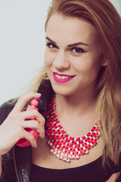 Girl with perfume, young beautiful woman holding bottle of perfume