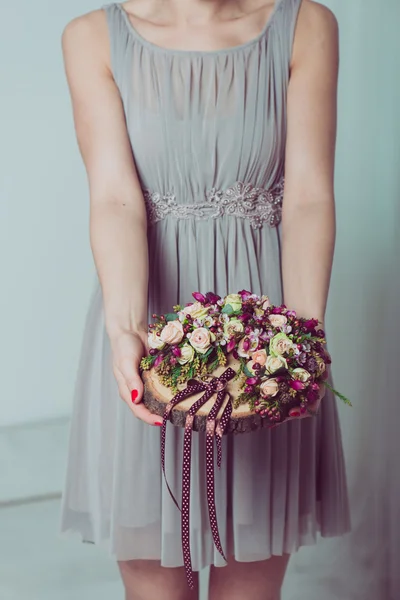 Bridesmaid holding wedding rings on flower decorations. — Stock Photo, Image