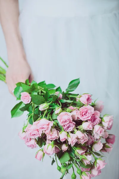 Retrato de una novia de boda posando en un vestido blanco con flores en sus manos. El ramo hermoso de boda en las manos de la novia . — Foto de Stock