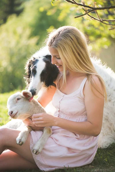 Щаслива блондинка грає з її Російська собака вовкодав в саду — стокове фото