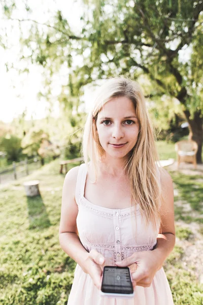 Young blonde woman using cell phone outdoor. — Stock Photo, Image