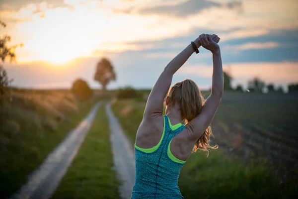 Desportista de sucesso feliz levantando braços para o céu em dourado volta iluminação pôr do sol verão. atleta de fitness com braços para cima comemorando objetivos após esporte exercitar e trabalhar ao ar livre . — Fotografia de Stock