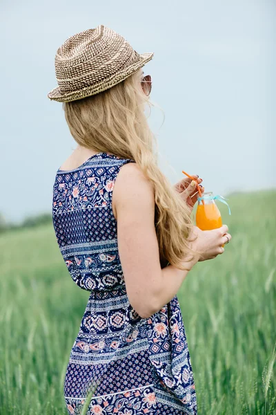 Kobieta picia sok pomarańczowy uśmiechnięty i stwarzających na zewnątrz. — Zdjęcie stockowe
