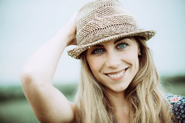 Retrato de una mujer bastante alegre con vestido blanco y sombrero de paja en un día soleado de clima cálido. Caminar en el parque de verano y sonreír —  Fotos de Stock