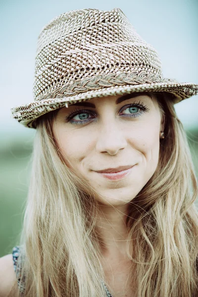 Portrait of pretty cheerful woman wearing white dress and straw hat in sunny warm weather day. Walking at summer park and smiling — Stock Photo, Image