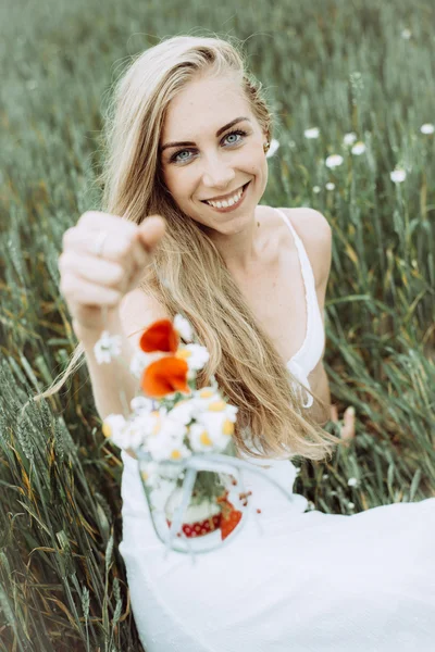 Piękna dziewczyna z kwiatami na lato park. Kobieta blonde zbieranie kwiaty. — Zdjęcie stockowe