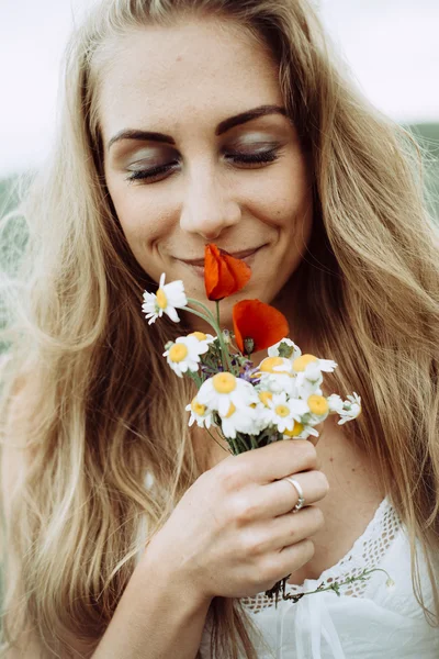 Hermosa joven feliz disfrutando del olor en un jardín de primavera floreciente — Foto de Stock