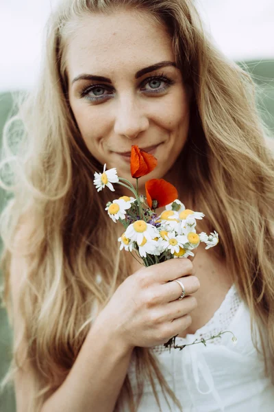 Mulher jovem feliz bonita desfrutando cheiro em um jardim de primavera florido — Fotografia de Stock