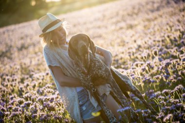 Kız köpekle oynuyor.