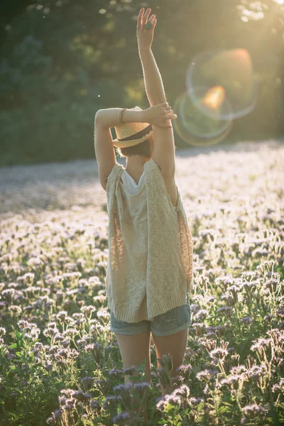 Godimento - donna felice e libera che si gode il tramonto. Bella donna che abbraccia il sole dorato bagliore del tramonto con le braccia divampate godendo la pace, la serenità nella natura — Foto Stock