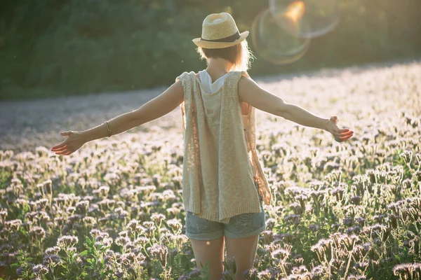 Disfrutar - mujer feliz libre disfrutando de la puesta del sol. Hermosa mujer abrazando el sol dorado resplandor de la puesta de sol con los brazos extendidos disfrutando de la paz, la serenidad en la naturaleza — Foto de Stock