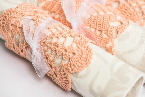 Servilletas blancas en servilleta rosa anillo vintage sentado en un plato. Fondo textil de lino. DOF poco profundo . — Foto de Stock