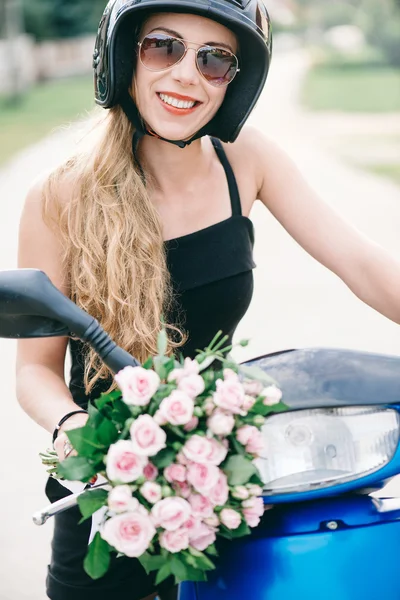 Donna allegra consegna rose rosa con scooter — Foto Stock