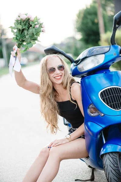 Nahaufnahme Lifestylebild einer jungen modischen Frau in lässigem Outfit, die auf einem Motorroller auf der Straße sitzt. Touristin genießt Urlaub . — Stockfoto