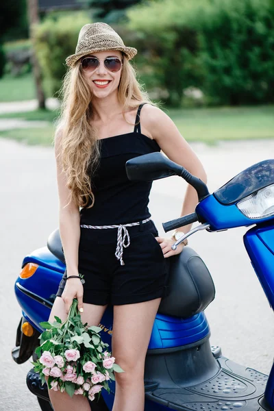 Ritratto di ragazza sorridente su scooter con in mano un mazzo di rose rosa - All'aperto per strada — Foto Stock