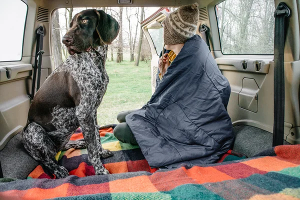 Mujer y su perro descansando en el interior del coche — Foto de Stock