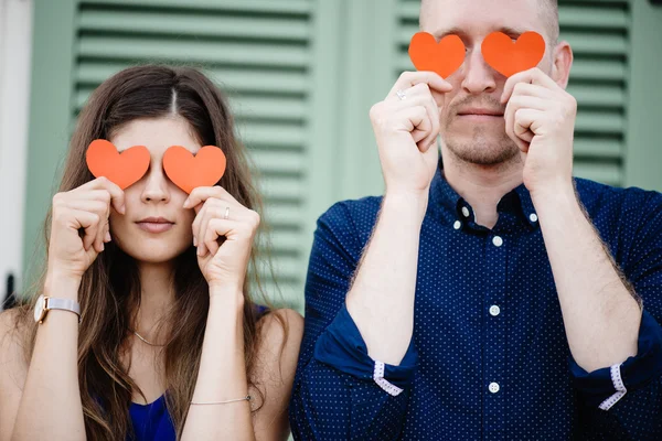 Casal segurando símbolos coração vermelho — Fotografia de Stock