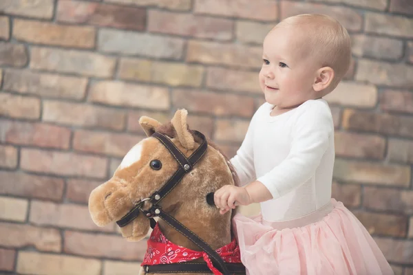 Ребенок играет с качающейся лошадью — стоковое фото