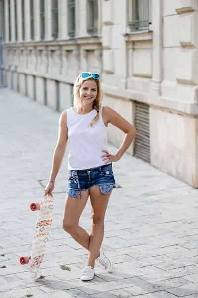 Skateboarder meisje poseren bij city — Stockfoto