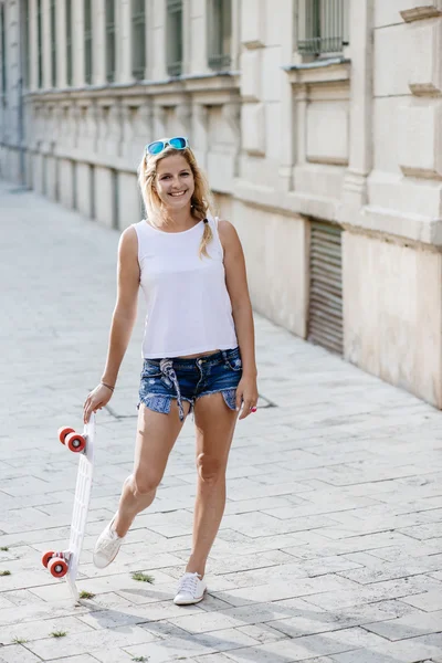 Skateboarder girl posing at city — Stock Photo, Image