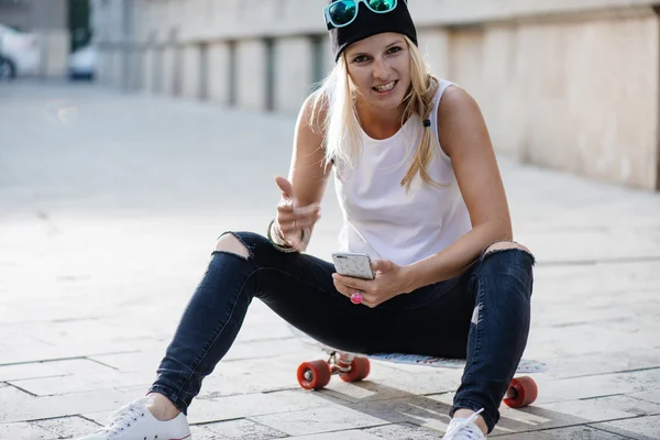 Skater meisje met mobiele telefoon — Stockfoto