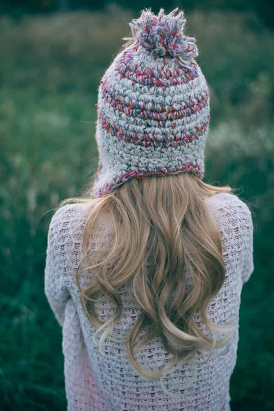 Довге волосся жінка дивиться в трикотажний капелюх — стокове фото