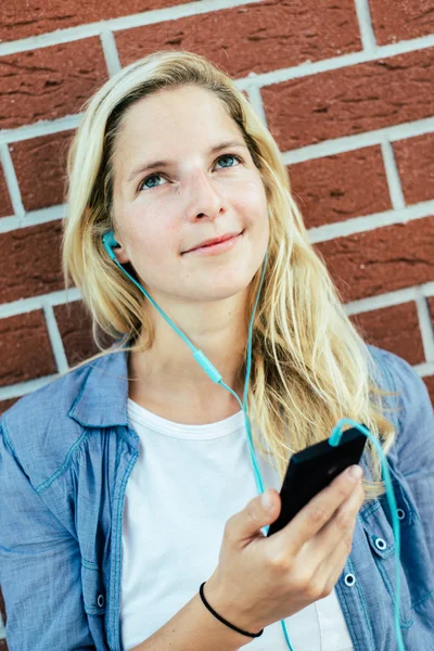 Chica escuchando música desde el teléfono inteligente —  Fotos de Stock