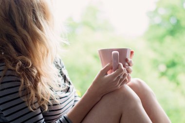 Peaceful woman relaxing at home with cup of tea or coffee clipart