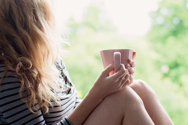 Vreedzame vrouw thuis ontspannen met een kopje thee of koffie — Stockfoto