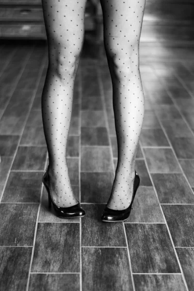 Slanke vrouwelijke benen in donkere kousen dragen hoge hakken — Stockfoto