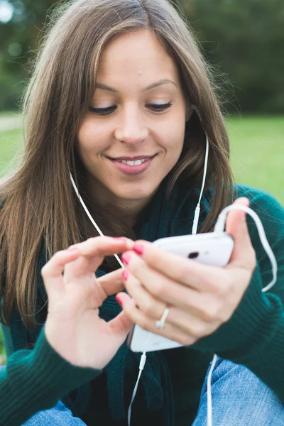 Vacker brunett dam röra och surfar hennes smarta telefonen — Stockfoto