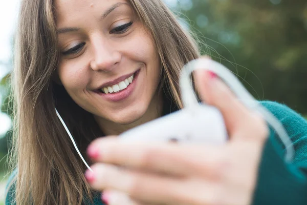 아름 다운 갈색 머리 아가씨 감동과 그녀의 스마트 휴대 전화 검색 — 스톡 사진
