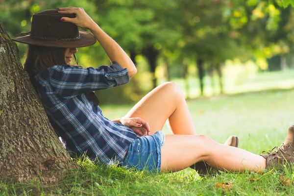 Cowgirl leží na poli relaxační a užijte si přírody — Stock fotografie