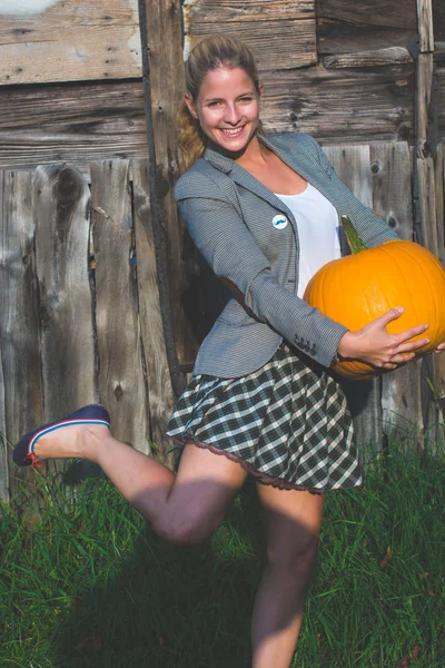 Frau hält Halloween-Kürbis in der Hand — Stockfoto