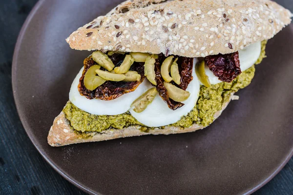 Gourmet sandwich with pesto sauce and olives — Stock Photo, Image