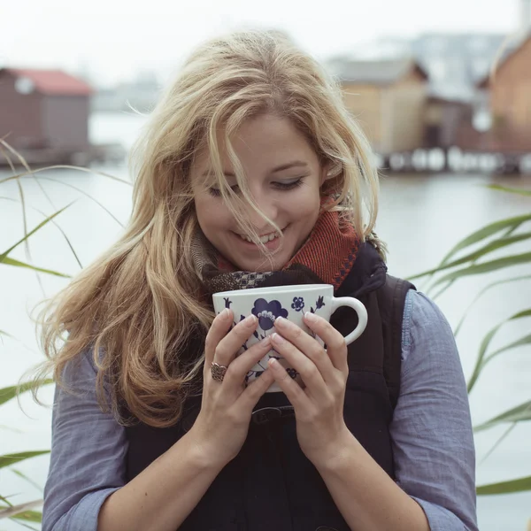 Usmíval se módní blondýnka pití horké nápoje — Stock fotografie