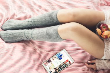 Kadın yatakta kahvaltı yapıyor.