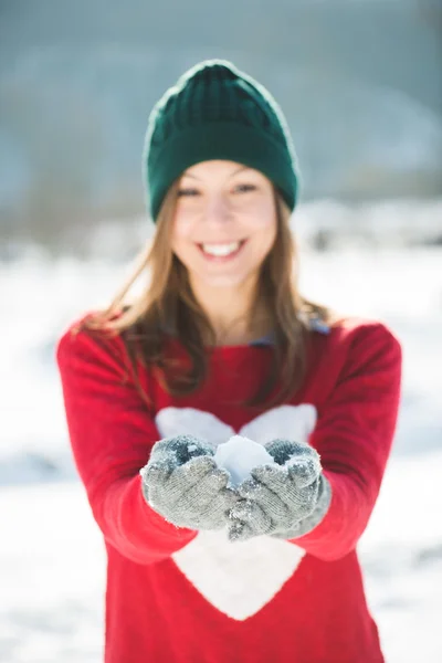 Девушка играет со снегом в парке — стоковое фото