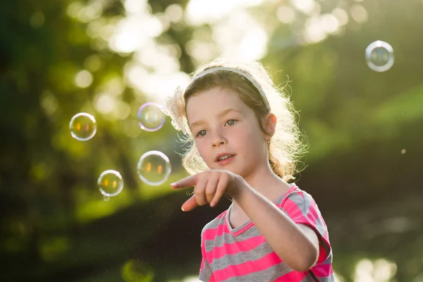 Petite fille joue avec des bulles de savon — Photo