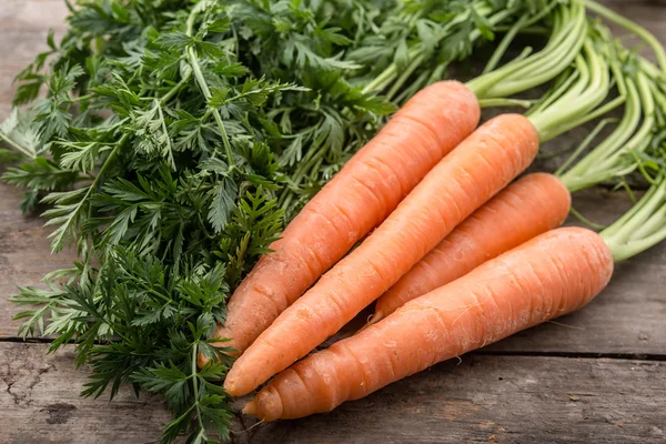 Fresh and ripe carrots on wooden background — Stock Photo, Image