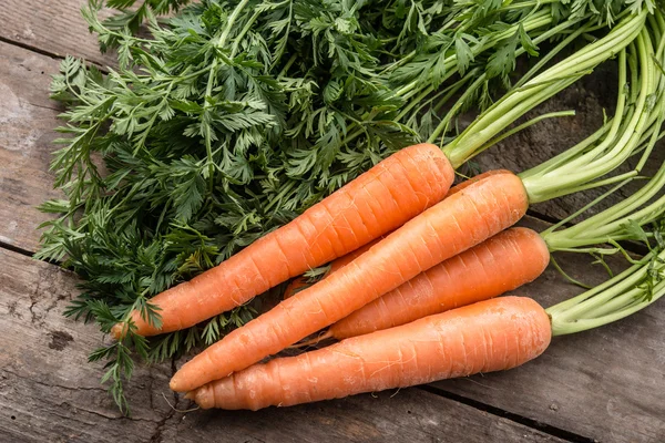 Zanahorias frescas y maduras sobre fondo de madera — Foto de Stock