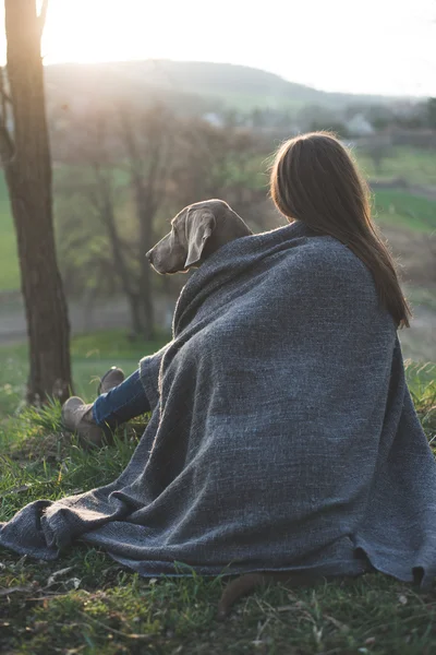 Femme avec son beau chien couché à l'extérieur, regardant coucher de soleil — Photo