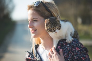 Kediyle oynayan kadın.