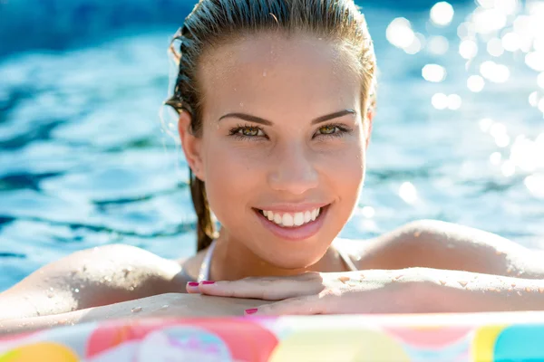プールでリラックスしたブルネットの笑顔の女性 — ストック写真