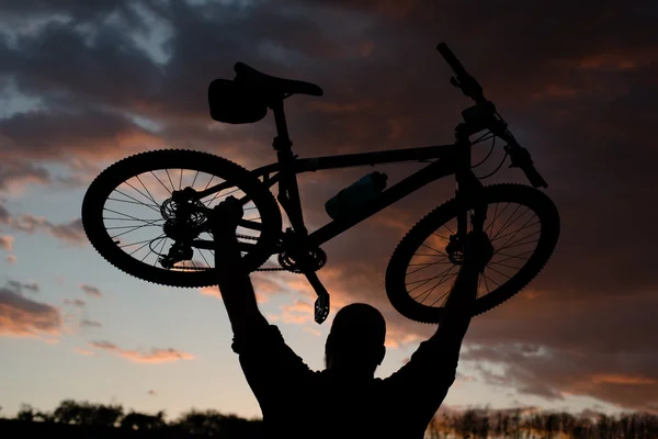 Silueta kolo Rider na skále při západu slunce — Stock fotografie